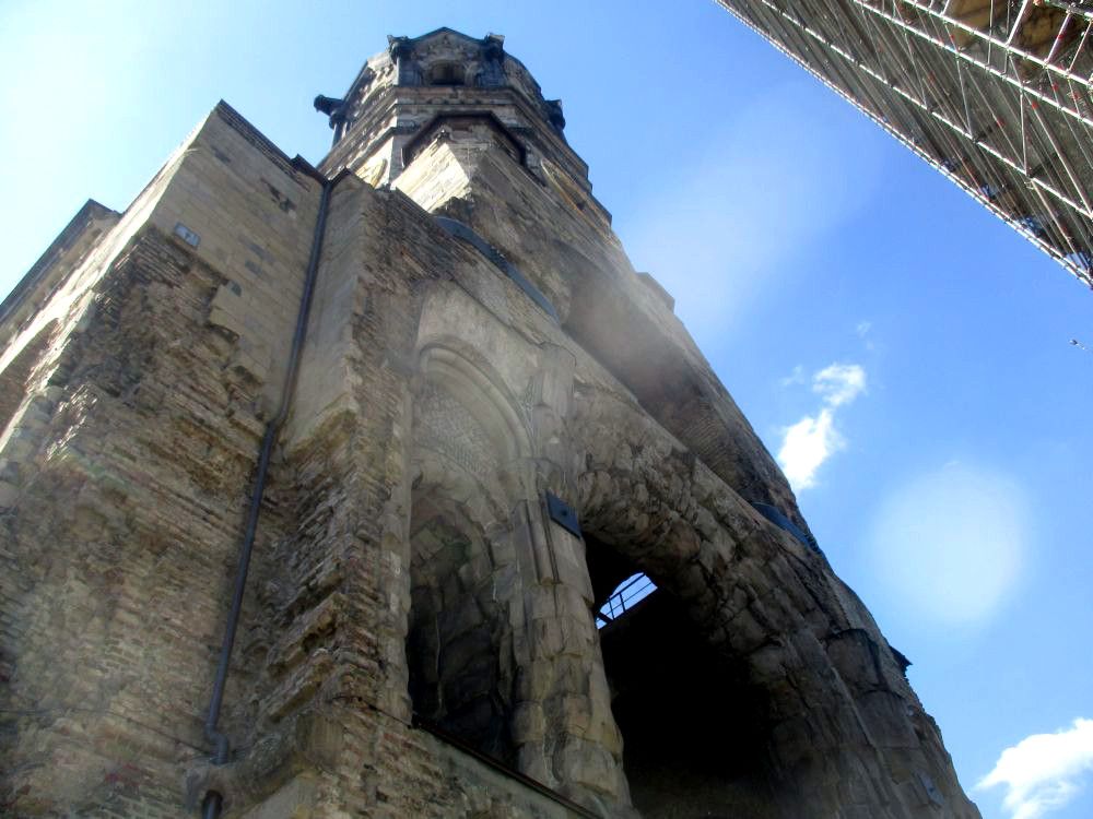 Die Gedächtniskirche in Berlin. Zu sehen ist die Seite des Turmes, auf dem einmal der Rest der Kirche angebaut war. Dad Gebäude ist quasi an dieser Stelle abgerissen, und alte Durchgänge klappen wie offene Wunden ins Freie.