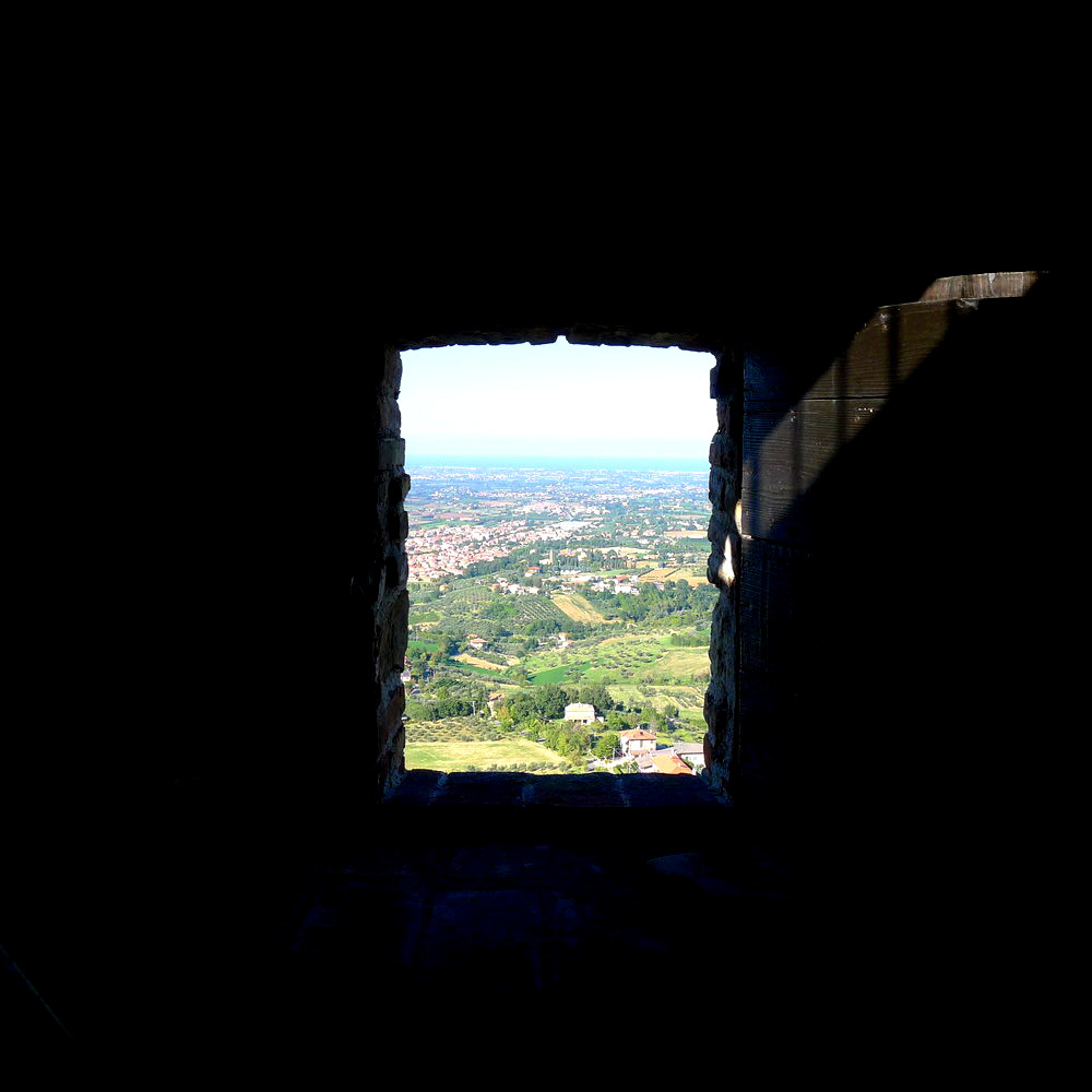 Ausblick dur eich Turmfenser der Rocca del Sasso in Verucchio. Die Aussicht reich bis zum Mittelmeer. Dazwischen liegen fruchtbare Felder.