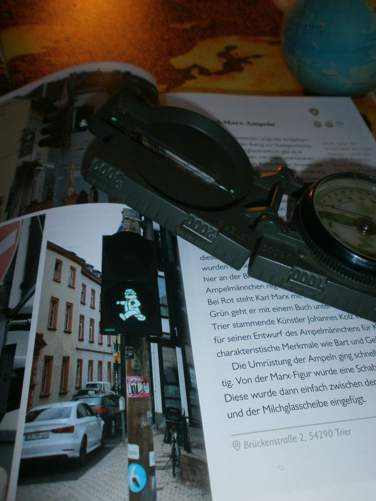 Buch aufgeschlagen auf eine Seite, die ein Bild von einer Karl Marx Ampel zeigt.