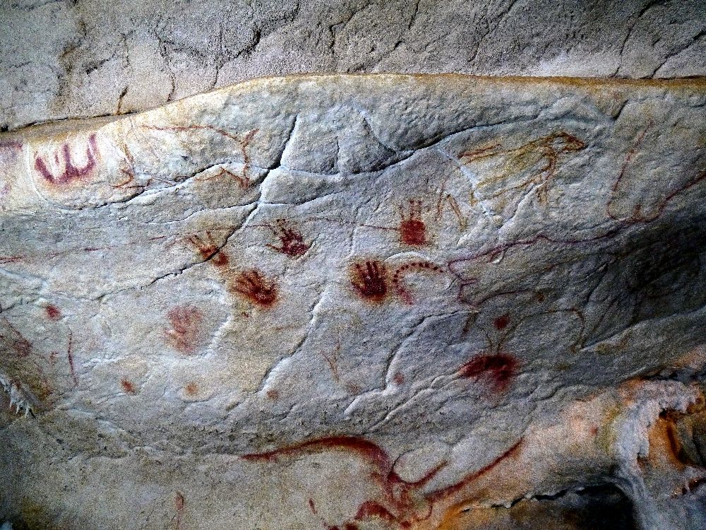 Rote Handabdrücke aus der Grotte Chauvtte. es handelt sich um 6 Altsteinzeitliche Handabdrücke aus roter Farbe, di auf einen Grauen Stein gemacht wurden.