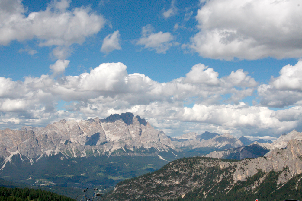 Blick in die Alpen. Das Bergmassov ist unter einem strahlenblauen Himmel, mit kleinen Wölkchen zu sehen.