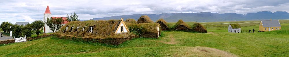 Gebäude aus Gras die dicht aneiander gebaut sind. sie stehen in einer art halbkreiscluster zueinander.