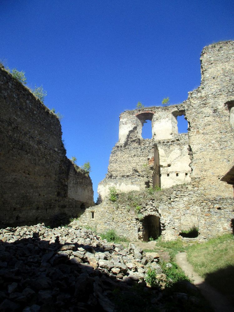 Ein Blick auf die Burgruiene, die Mauern sind teilweise Abgetragen, udn teilsweise stehen die Mauern aber noch mehrer Geschoss hoch bis dierekt daneben.