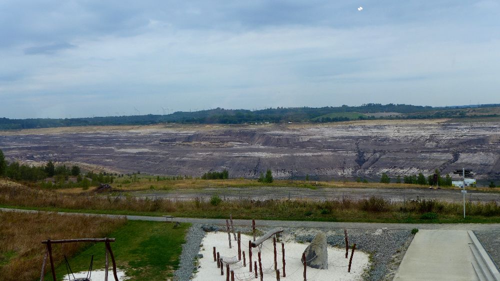 Blick in ein riesiges Loch in der Landschaft hinter dem Spielplatz.