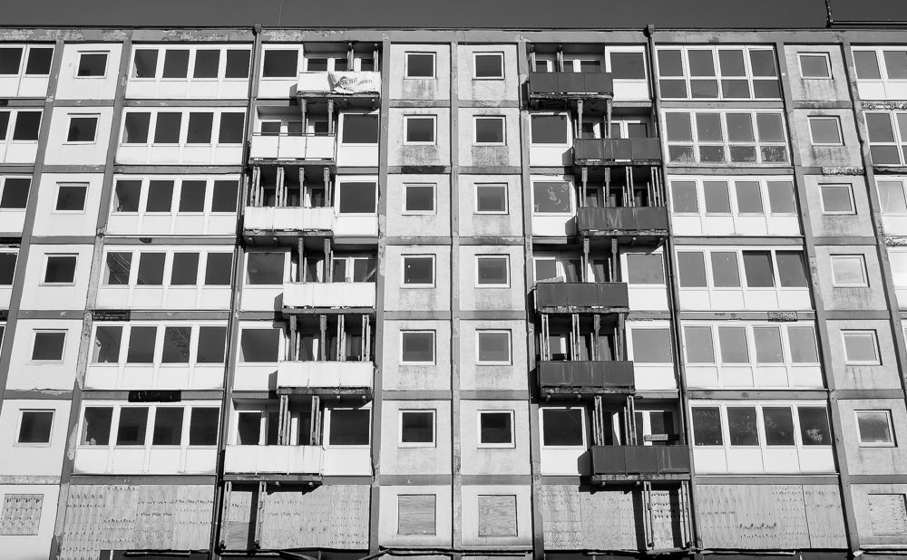 Ein Marodes Hochhaus mit improvisierten Holzstützen, die die Balkone halten.