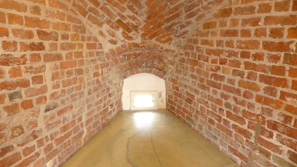 Eine Schießscharte im Holstentor, die Wand verläuft sich zur Öffnung hin verjüngend, damit man diese Schießscharte überhaupt nutzen kann. Eindrucksvolle 3 Meter Dicke Wände umgeben das winzige Loch durch das Licht fällt.