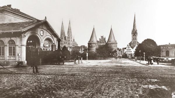 Das erste Bahnhofsgebäude Lübecks wurde 1851 an der Stelle eröffnet an dem zuvor einmal das Barocke äußere Holstentor Stand.