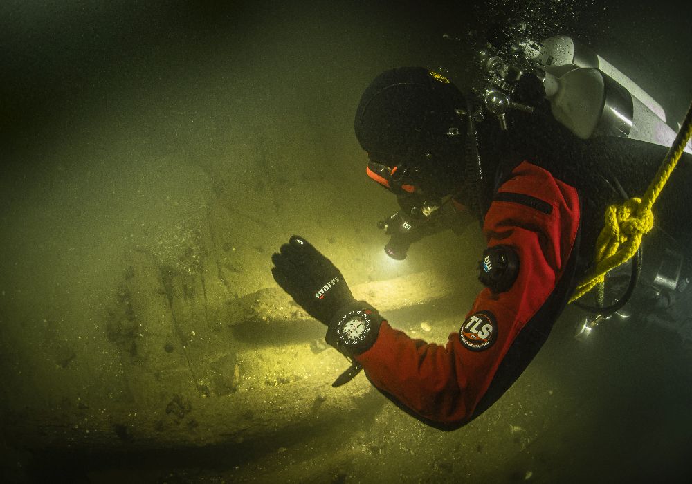 Ein Taucher im Wasser über ein Paar Holzplanken