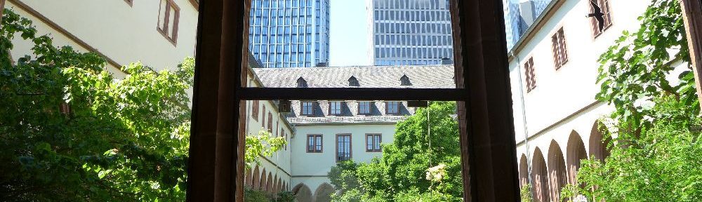 Ein mittelalterlicher Garten in einem Innenhof, dahinter sind wolkenkratzer zu sehen.