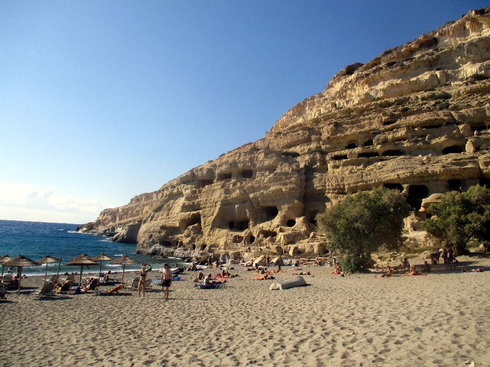 Ein Orang leuchtendes Sandsteinmassiv, das ins Meer ragt.