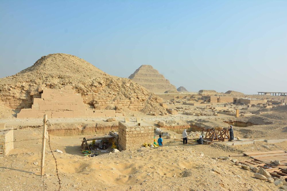 Im Hintergrund die Pyramide von Sakkara, im Vordergrund: Arbeiter in der Wüste.