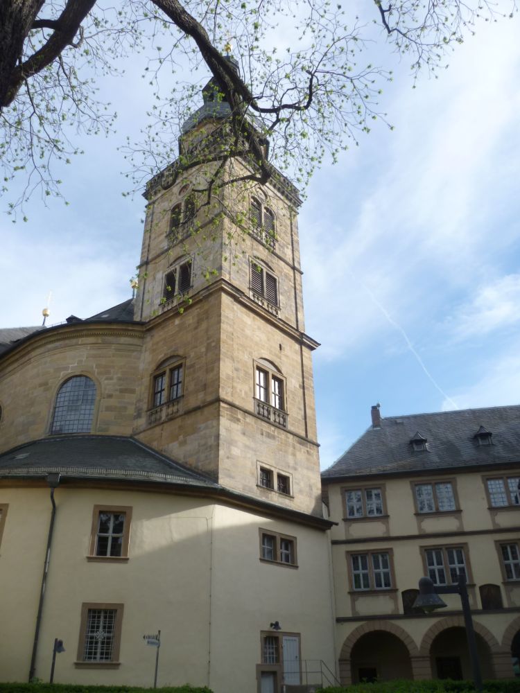 Ein drei Stockwerke hoher Sandsteinturm mit einem gezwiebelten Kuppeldach.