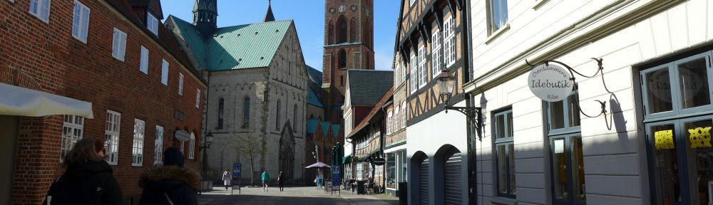 Der Dom zu Ribe am Ende einer Gasse, die mit Fachwerkhäusern gesäumt ist.