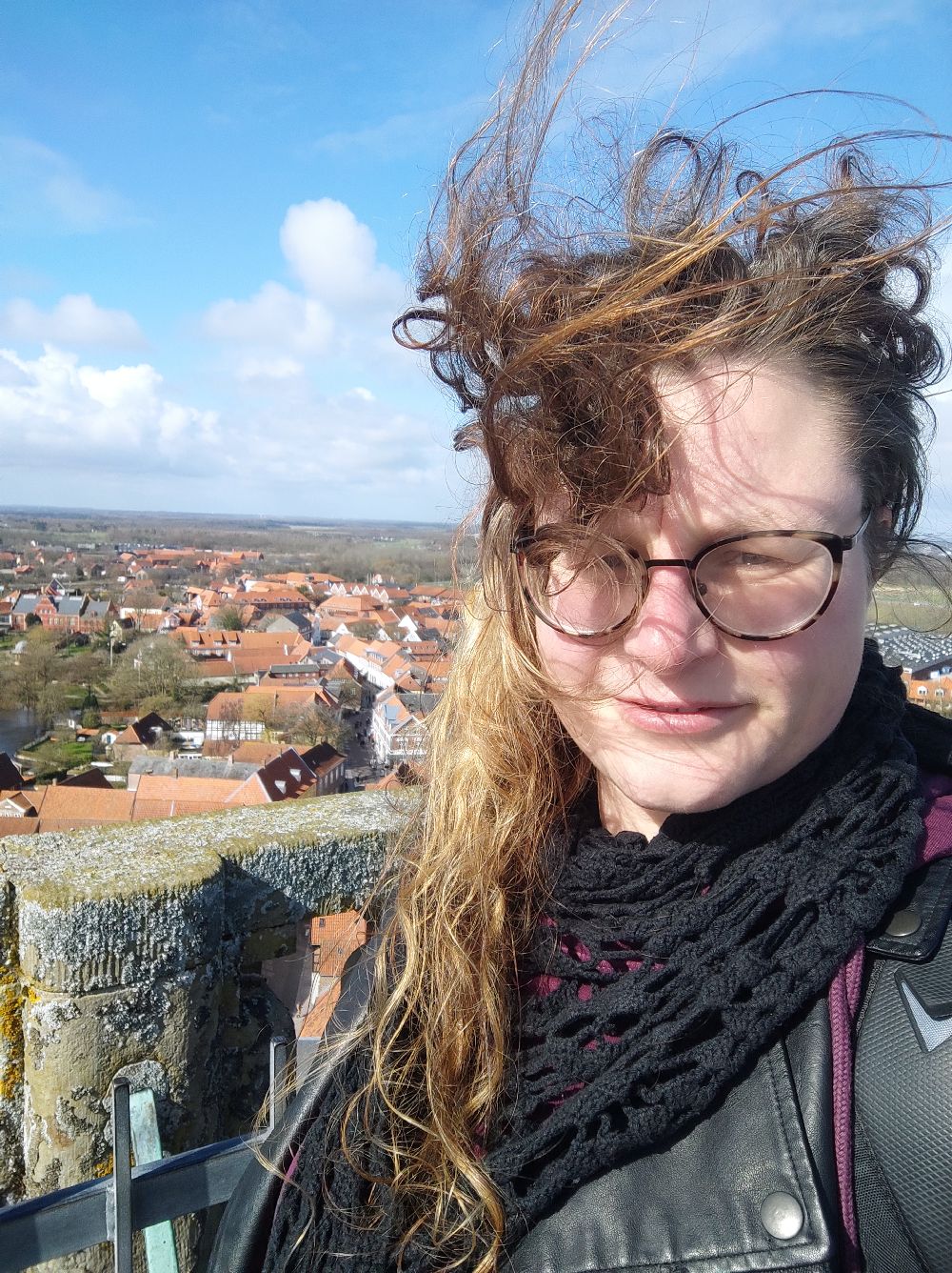 Ich auf dem Turm, der Wind ist so stark, dass mir die Haare in alle Richtungen wehen.